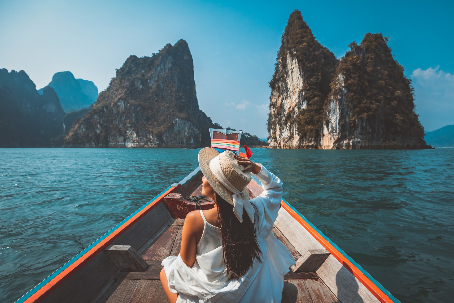 Traveler asian woman relax and travel on Thai longtail boat in Ratchaprapha Dam at Khao Sok National Park Surat Thani Thailand