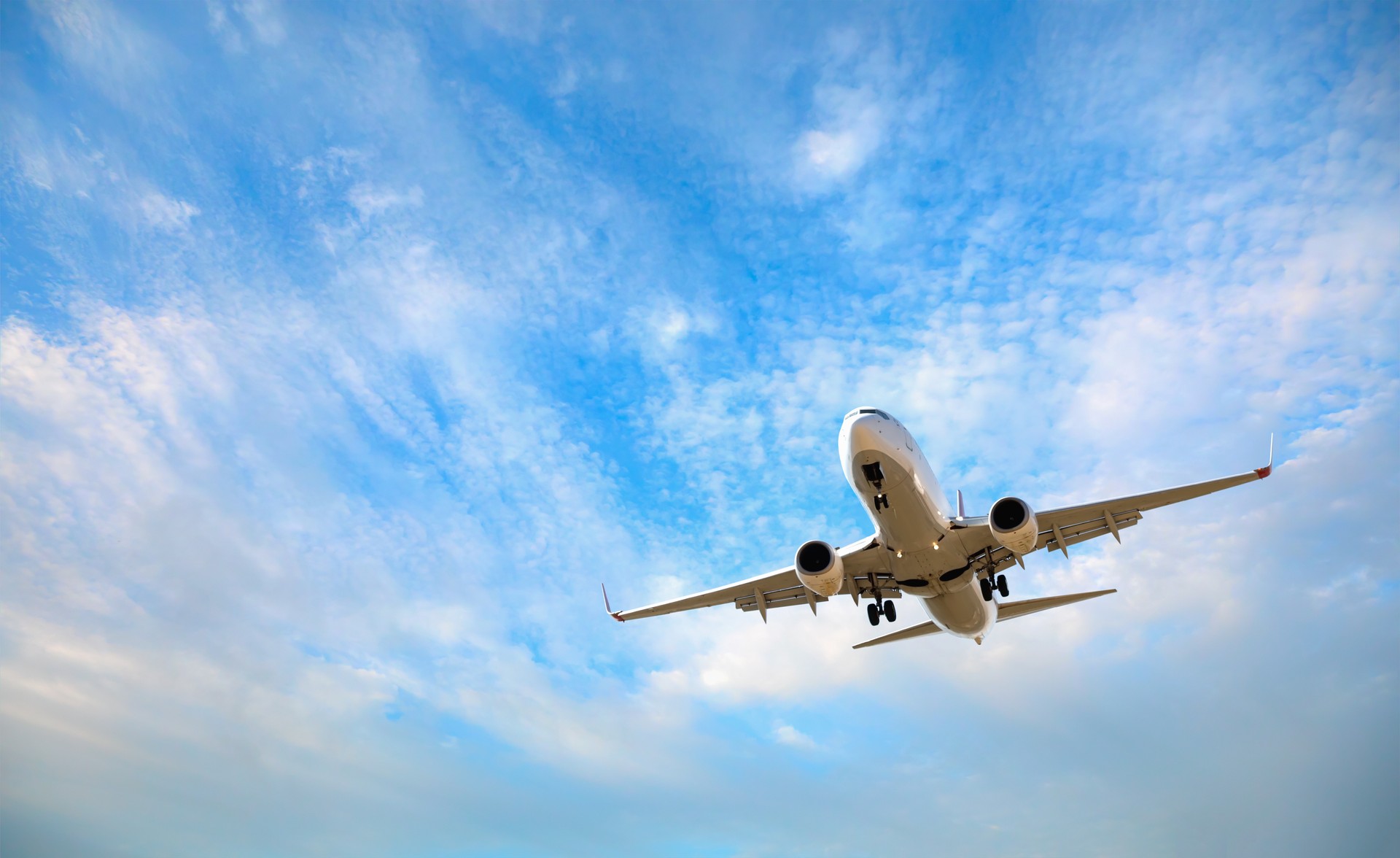 White passenger airplane flying in the sky amazing clouds in the background